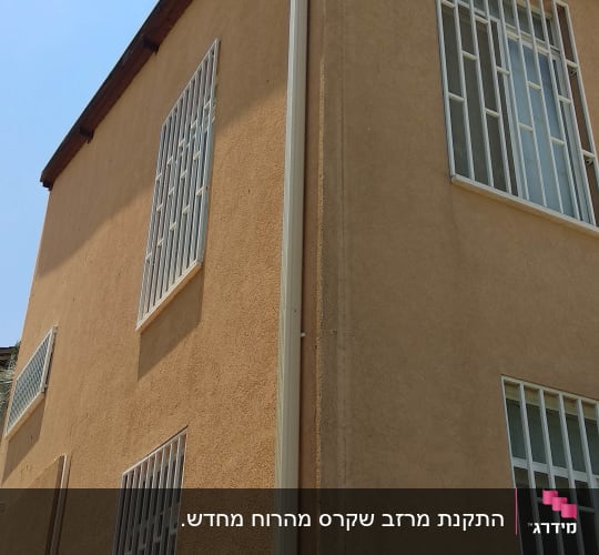 מרזב לבן מחובר לגג רעפים חום